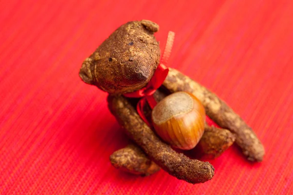 Medvídek ručně a ořechy na červeném pozadí — Stock fotografie