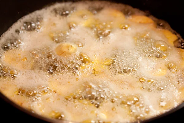 Bananas in the pan in boiling caramel — Stock Photo, Image
