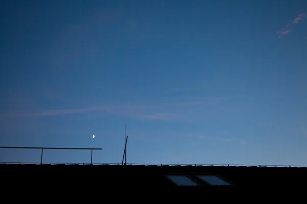 지붕과 집의 실루엣을 통해 저녁 하늘 — 스톡 사진