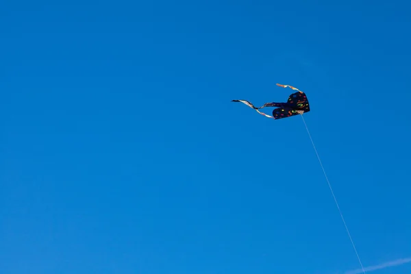 Воздушный змей летит на фоне голубого неба — стоковое фото