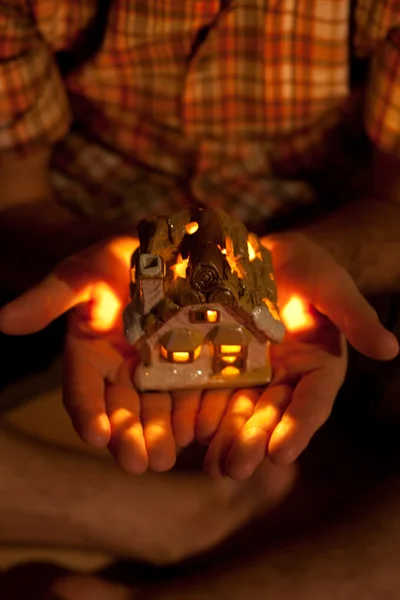 Casa decorativa com uma vela nas mãos do homem — Fotografia de Stock