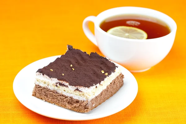 Citromos tea és sütemény a narancssárga szövet — Stock Fotó