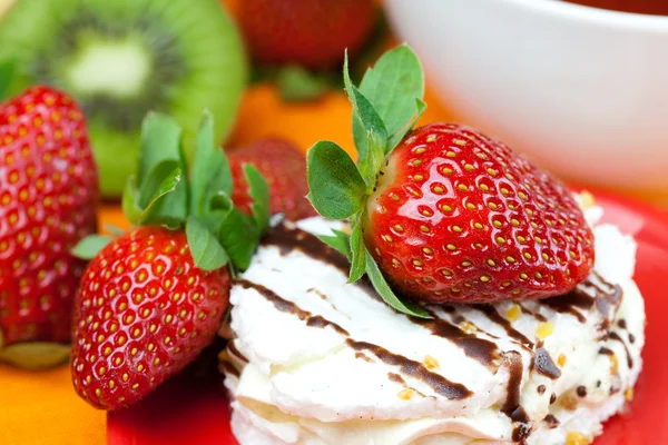 Kiwi, Kuchen und Erdbeeren liegen auf dem orangefarbenen Stoff — Stockfoto