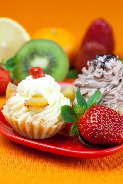 Citroen, Mandarijn, kiwi, taart en aardbeien liggend op de oranje fa — Stockfoto