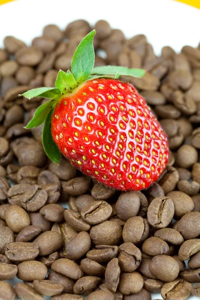 Aardbeien liggend op een achtergrond van koffie bonen — Stockfoto