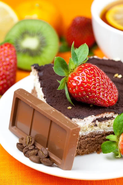 Lemon tea,chocolate, kiwi,cake and strawberries lying on the ora — Stock Photo, Image