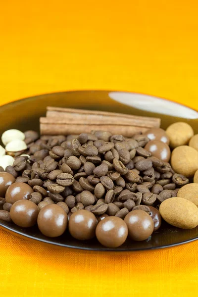 Plate of coffee beans, cinnamon and the sweets — Stock Photo, Image