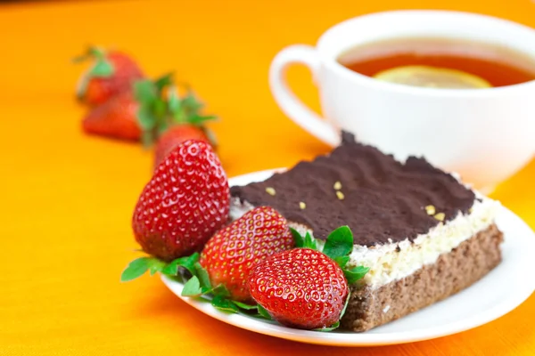 Τσάι λεμονιού, κέικ και φράουλες ξαπλωμένες στο πορτοκαλί ύφασμα — Φωτογραφία Αρχείου