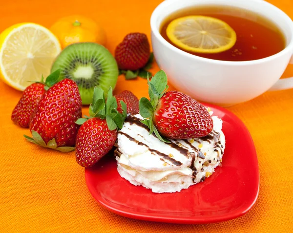 Té de limón, limón, mandarina, kiwi, pastel y fresas que se encuentran en t — Foto de Stock