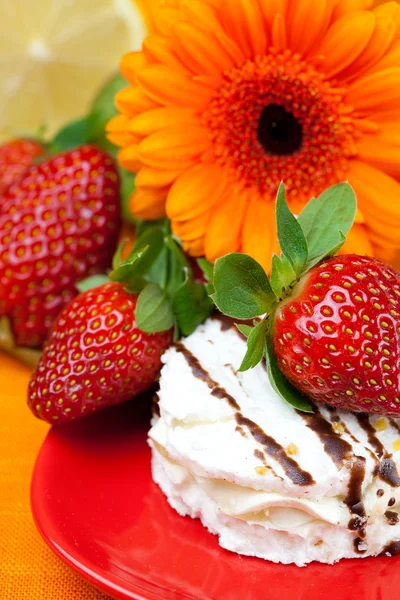 Lemon ,gerbera,cake and strawberries lying on the orange fabric — Stock Photo, Image