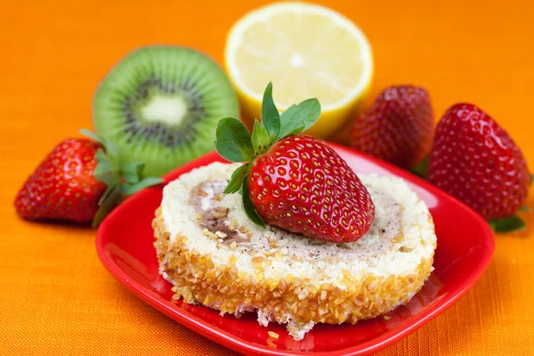 stock image Cake,kiwi,lemon and strawberries lying on the orange fabric