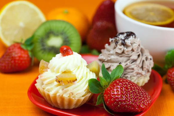 Lămâie, ceai de lămâie, mandarină, kiwi, tort și căpșuni întinse pe — Fotografie, imagine de stoc