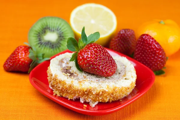 Cake,kiwi,lemon,mandarin and strawberries lying on the orange fa — Stock Photo, Image