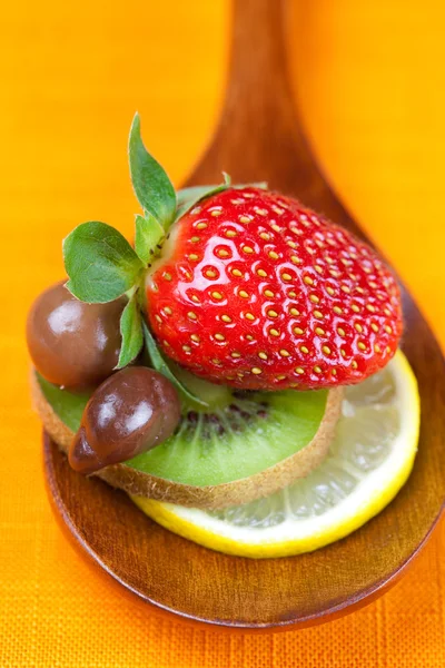 イチゴ、キウイ、th の木のスプーンでチョコレート ・ キャンディ — ストック写真