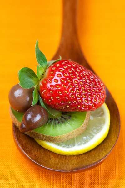 स्ट्रॉबेरी, कीवी और चॉकलेट कैंडी लकड़ी के चम्मच में — स्टॉक फ़ोटो, इमेज