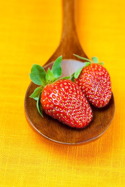 Strawberries in wooden spoon of the orange fabric — Stock Photo, Image