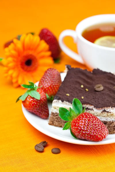 非洲菊、 柠檬绿茶、 蛋糕和草莓躺在橙色 fa — 图库照片