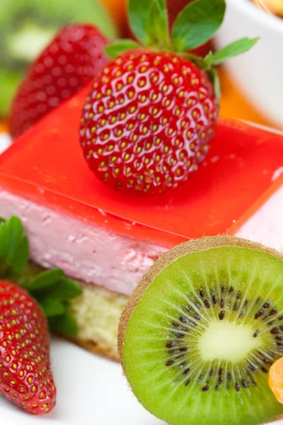 Lemon tea, kiwi,cake and strawberries lying on the orange fabric — Stock Photo, Image