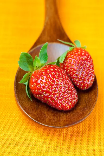 Strawberries in wooden spoon of the orange fabric — Stock Photo, Image