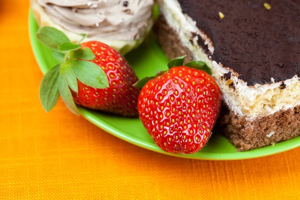 Tårta och jordgubbar liggande på orange tyg — Stockfoto