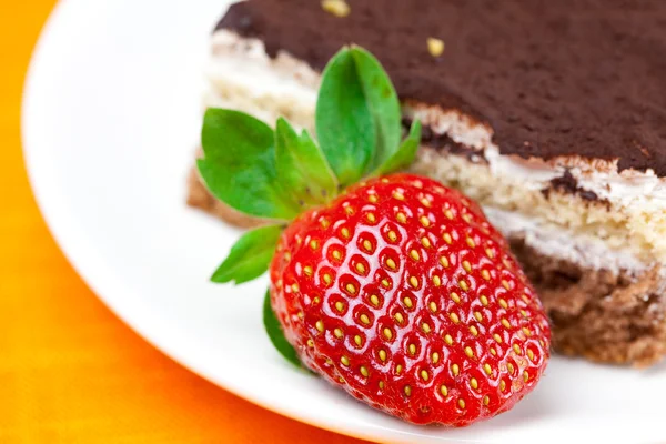 Cake en aardbeien liggend op het oranje weefsel — Stockfoto
