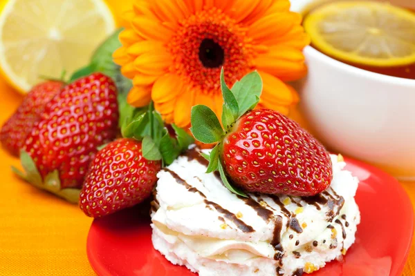 Citroenthee, citroen, gerbera, taart en aardbeien liggend op de oran — Stockfoto