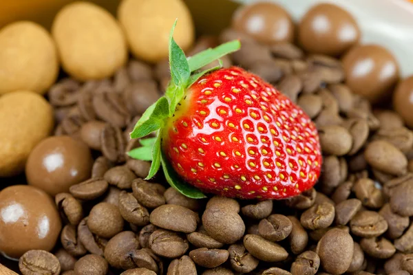 Aardbeien liggend op een achtergrond van koffiebonen, kaneel en — Stockfoto