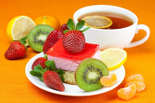 柠檬绿茶、 猕猴桃、 蛋糕和草莓躺在橙色织物上 — 图库照片