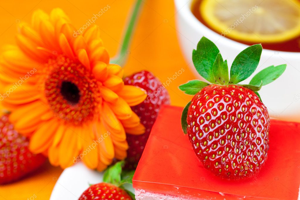 Gerberas, té de limón, tartas y fresas sobre la naranja fa: fotografía de  stock © evgeniyauvarova #6118327 | Depositphotos