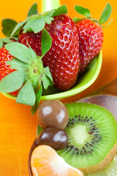 Strawberries, kiwi, mandarin orange, lemon and chocolate candy i — Stock Photo, Image