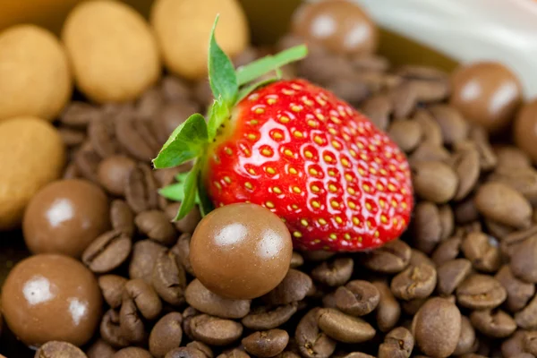 Strawberries lying on a background of coffee beans, cinnamon and — Stock Photo, Image