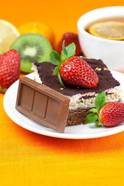 Zitronentee, Schokolade, Kiwi, Kuchen und Erdbeeren auf dem Boden liegend — Stockfoto