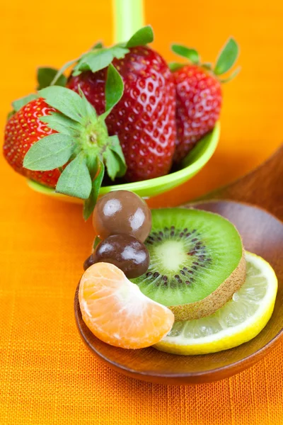 Strawberries, kiwi, mandarin orange, lemon and chocolate candy i — Stock Photo, Image