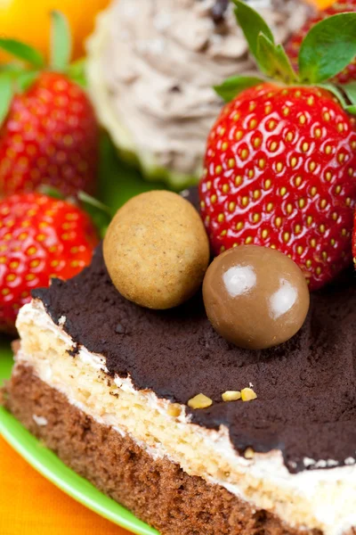 Cake, chocolates and the strawberries on the orange fabric — Stock Photo, Image