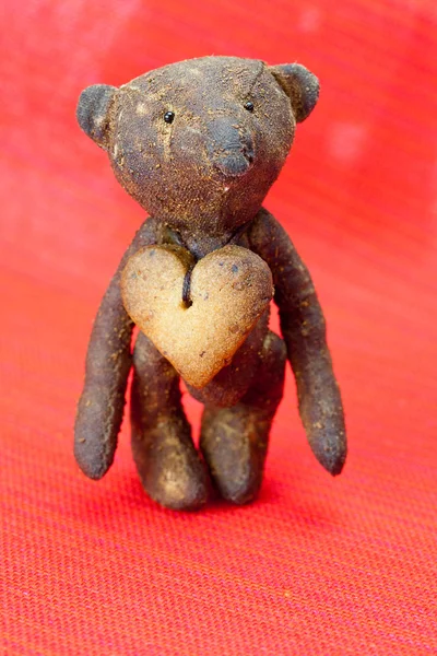 Ours en peluche fait à la main et biscuit en forme de coeur sur un b rouge — Photo