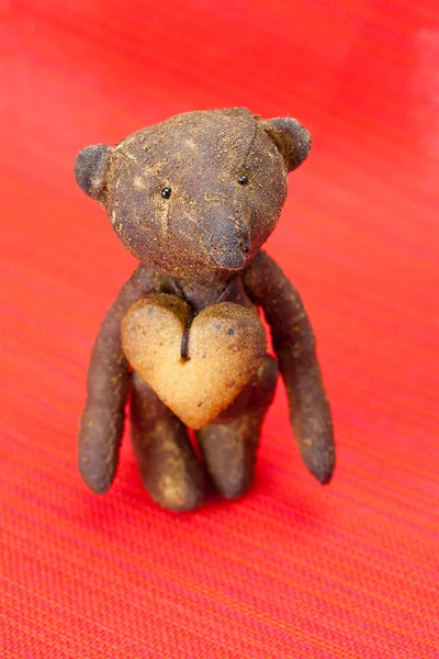 Osito de peluche hecho a mano y galleta en forma de corazón en un b rojo — Foto de Stock