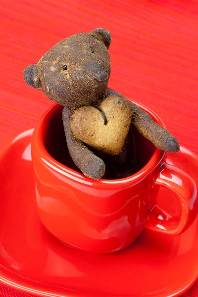 Osito de peluche hecho a mano y galleta en forma de corazón en una taza —  Fotos de Stock
