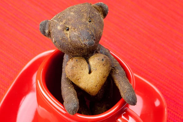 Ours en peluche fait à la main et biscuit en forme de coeur dans une tasse — Photo