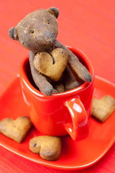 Osito de peluche hecho a mano y galleta en forma de corazón en una taza —  Fotos de Stock