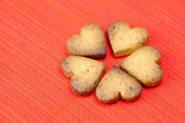 Cookie in de vorm van hart in een plaat op een rode achtergrond — Stockfoto
