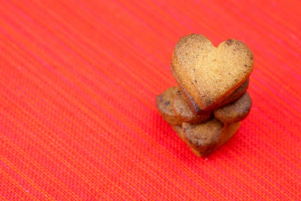 Biscotto nella forma di cuore in un piatto su uno sfondo rosso — Foto Stock