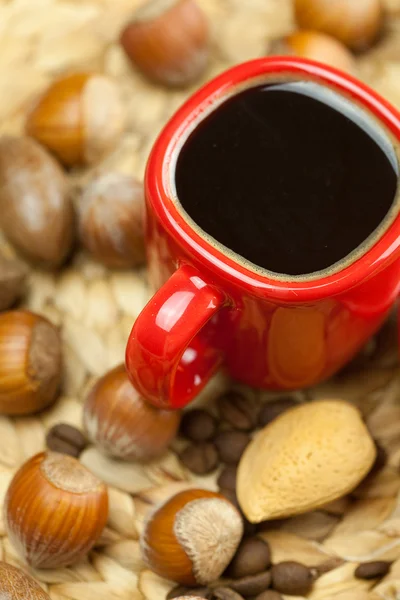 Taart op een plaat, noten en een kopje koffie op een rieten mat — Stockfoto