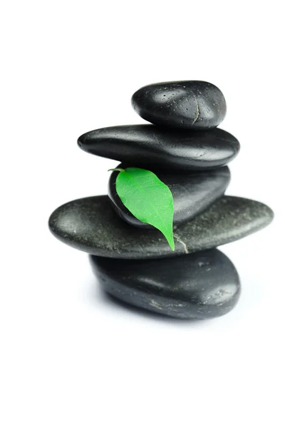 Zwarte spa stenen met groen blad en een druppel water geïsoleerd — Stockfoto