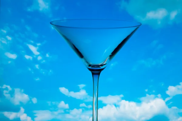 Концептуально освещенный бокал мартини против неба — стоковое фото