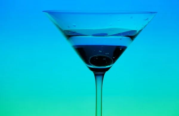 Концептуально освещенный бокал мартини на градиентном фоне — стоковое фото