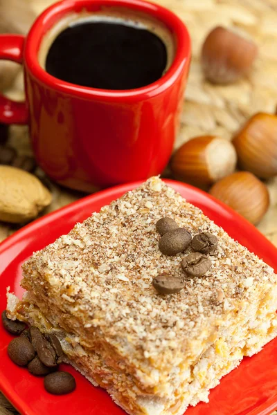 Taart op een plaat, noten en een kopje koffie op een rieten mat — Stockfoto