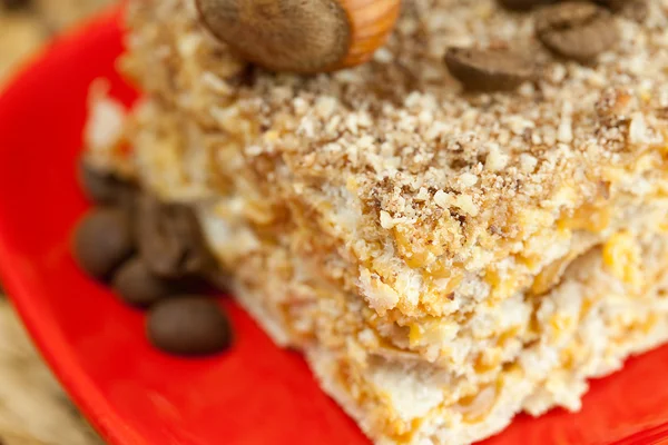 Kuchen auf einem Teller, Nüsse und eine Tasse Kaffee auf einer Weidenmatte — Stockfoto