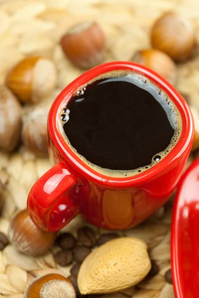 Torta su un piatto, noci e una tazza di caffè su un tappeto di vimini — Foto Stock