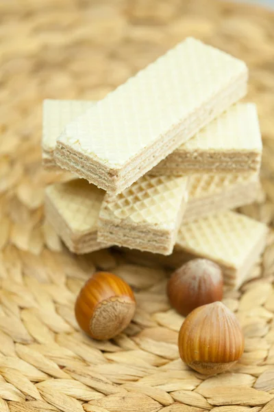 Sweet wafers and nuts lying on a wicker mat — Stock Photo, Image
