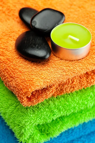 Achtergrond van de drie multi gekleurde badhanddoeken, spa zwarte sto — Stockfoto